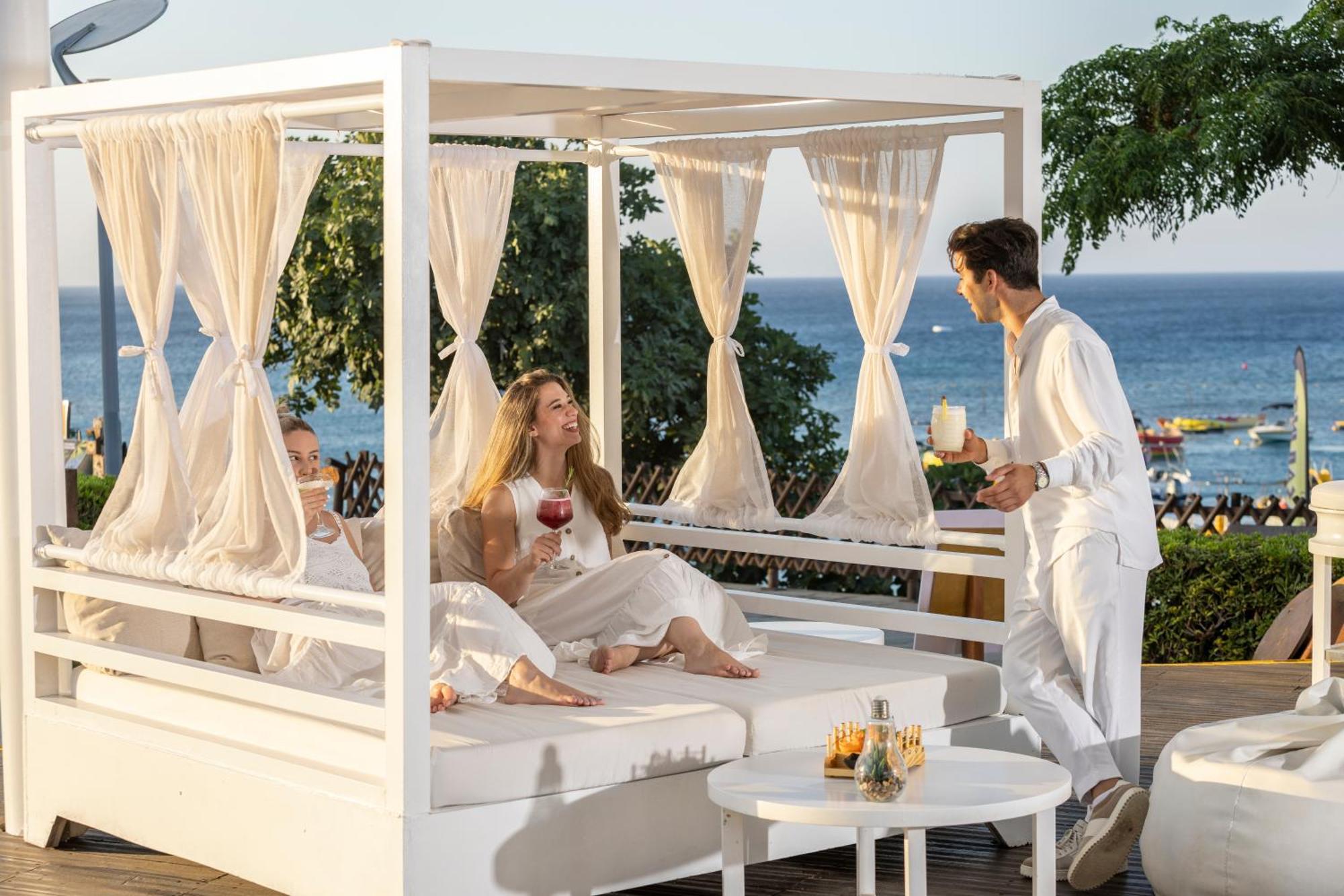 カポ ベイ ホテル プロタラス エクステリア 写真 A butler serving drinks at a resort